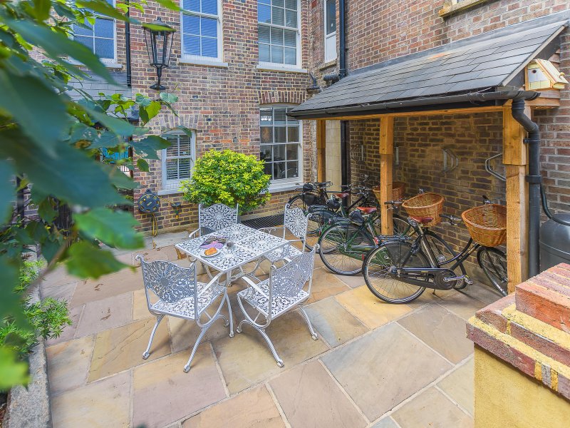 Brick courtyard with patio furniture, bicycles, and access to residential building