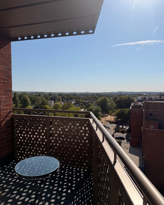 Balcony with decorative screen, table, and expansive suburban landscape view