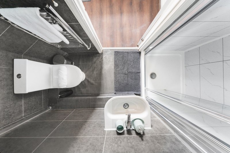 Overhead view of modern bathroom with toilet, sink, and shower enclosure