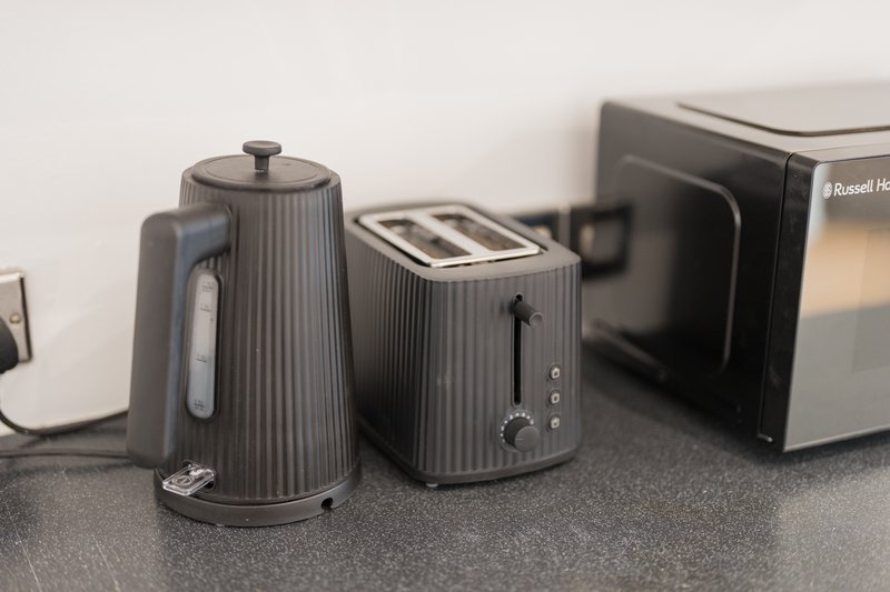 Kitchen countertop with dark grey kettle, toaster, and small appliances