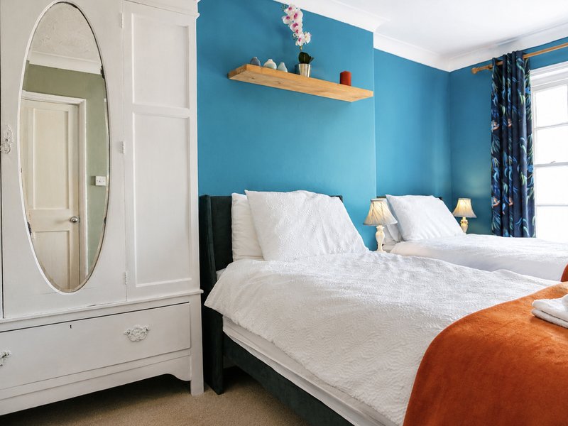 Bedroom 1 with twin beds, bedside drawers and wardrobe