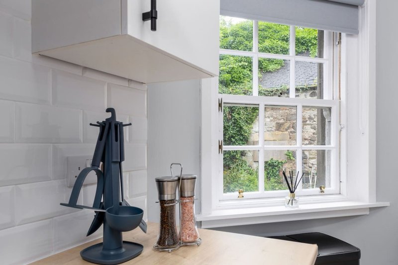 Kitchen counter with window, pepper mill, salt shaker and utensil holder