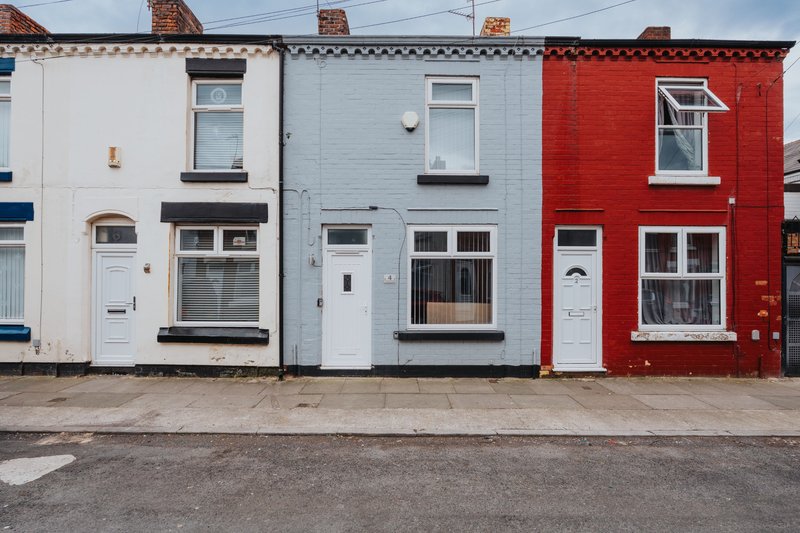 Terrace of three colorful townhouses with white, blue and red facades, street frontage