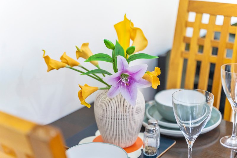 Dining table with floral centerpiece, place settings, and glassware