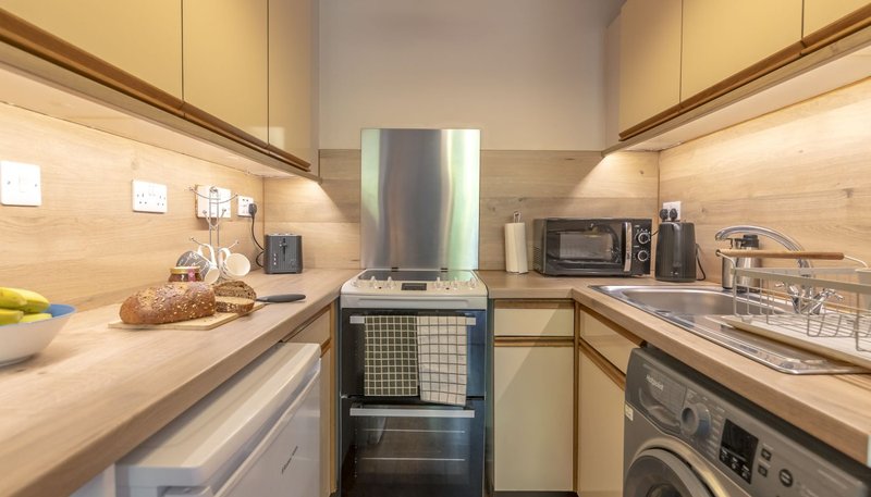 Modern kitchen with cream cabinets, wooden countertops, stainless steel appliances and island cooker
