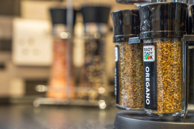 Kitchen countertop with spice jars and storage containers, blurred appliances in background