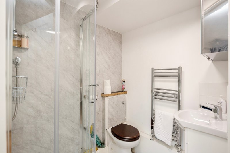 Modern bathroom with walk-in shower, toilet, sink, heated towel rail and mirror cabinet