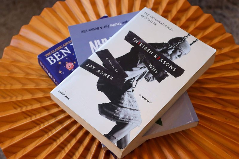 Stack of books arranged on orange pleated paper decoration