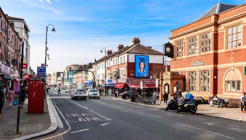 Street view of traditional British high street with period buildings, shops and clear blue sky