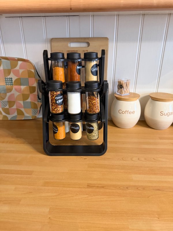 Kitchen counter with wooden storage organizer, spice containers, and ceramic coffee and sugar canisters