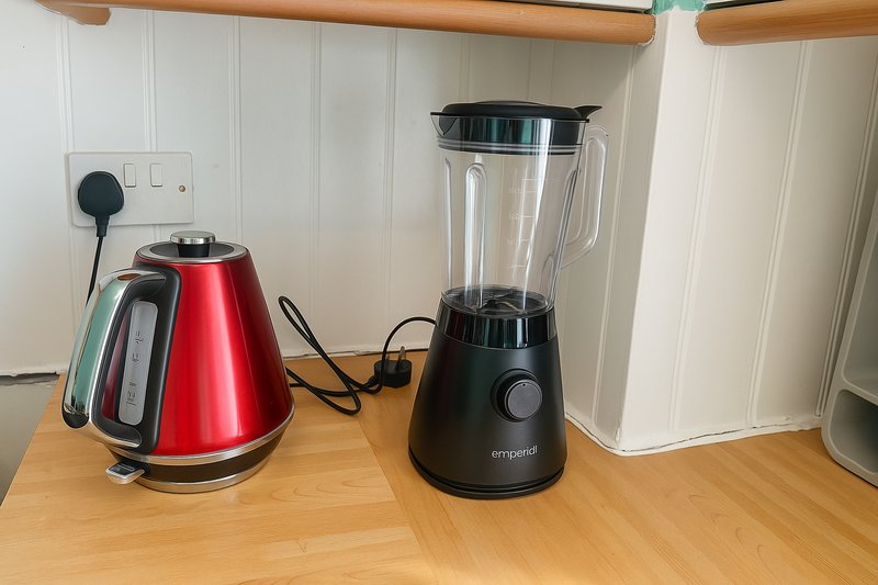 Kitchen counter with red kettle, black blender, and white storage container