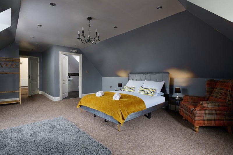 Comfortable king-size bedroom. A spacious, stylish retreat with a quality bed and plenty of room to relax after a long day. The en-suite bathroom adds extra convenience.
