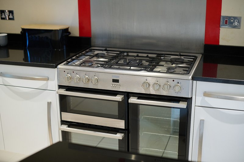 The spacious, fully equipped kitchen includes a large range cooker, multiple ovens, generous worktop space and the cupboards are stocked with everything you need to prepare meals.