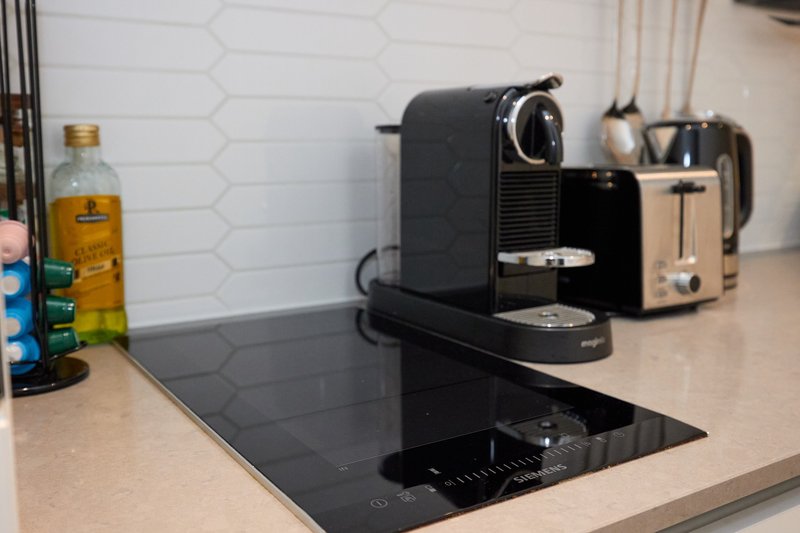 Kitchen countertop with coffee machine, toaster, induction hob and cooking items