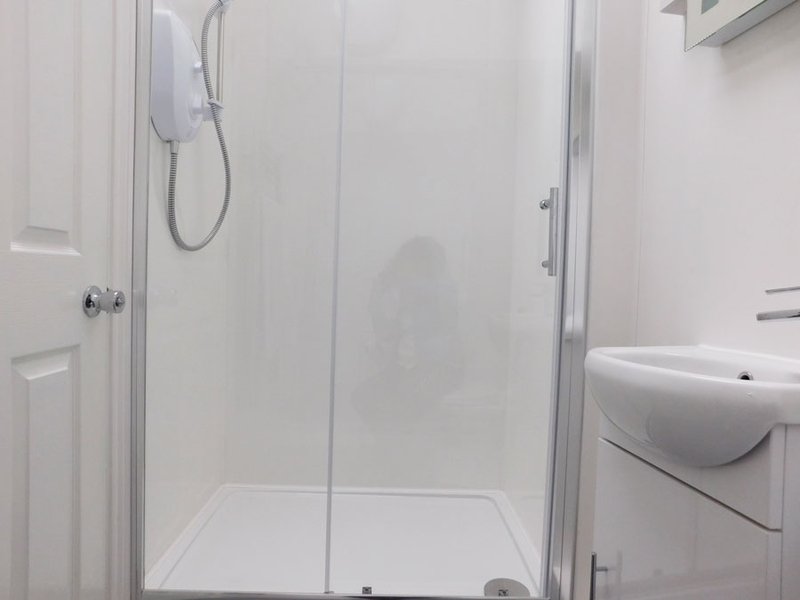 Modern bathroom with shower enclosure, white basin and clean white walls
