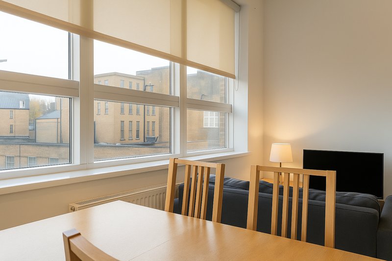 Dining area with wooden table, chairs, and large windows overlooking street