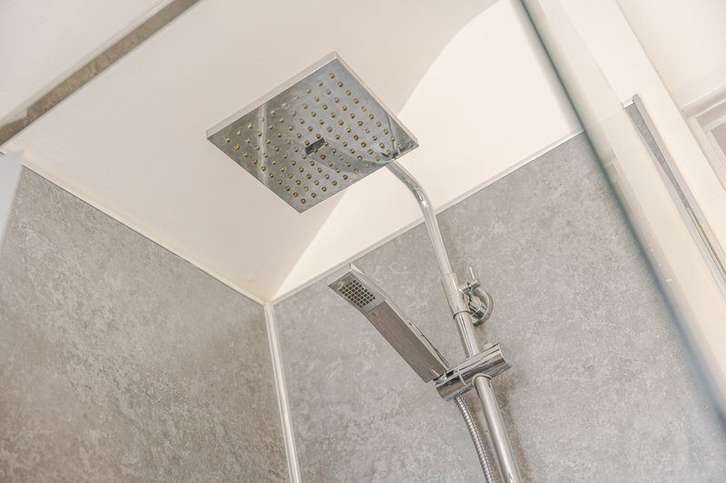 Modern bathroom shower head with rainfall fixture and handheld spray attachment