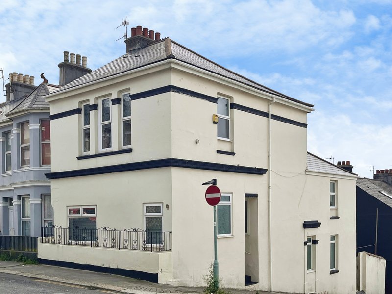 Corner townhouse with cream and navy exterior, multiple windows and pitched roof