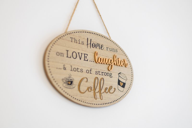 Wooden wall plaque with decorative text about home, love, laughter and coffee
