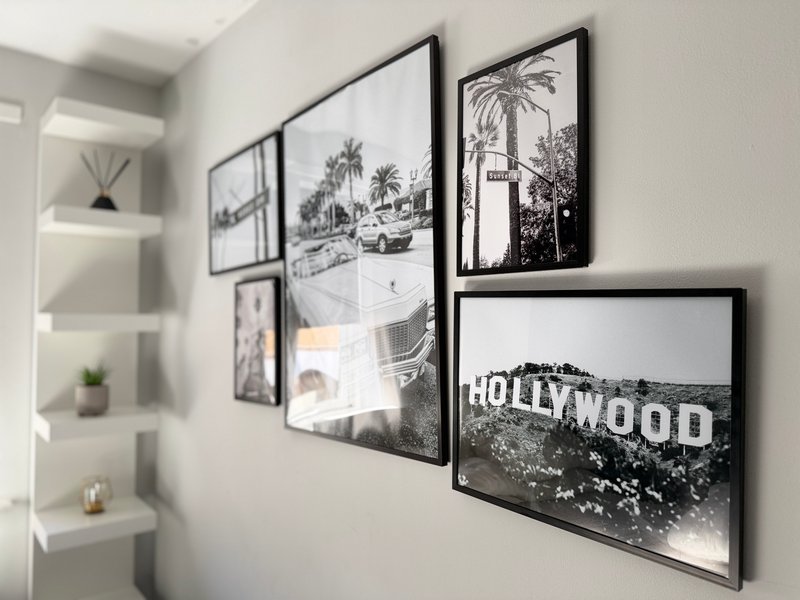 Modern bedroom wall with framed black and white prints and decorative shelving