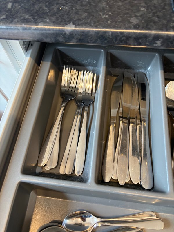 Kitchen drawer organizer with sorted cutlery and utensils in compartments