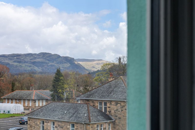 Hillside view from property with stone buildings, mountains and woodland in distance