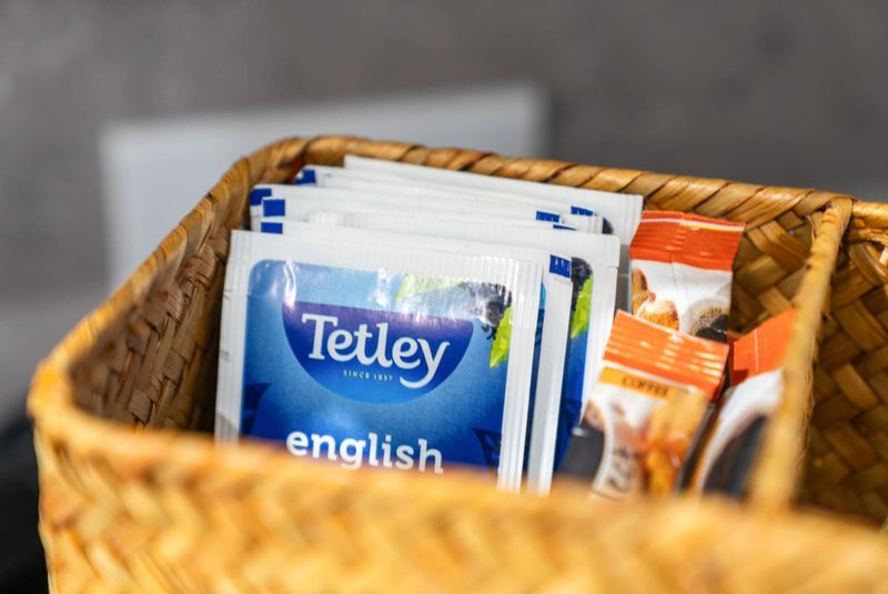 Wicker basket containing tea bags, packets and household items