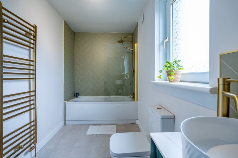 Modern bathroom with bath, shower enclosure, round sink and heated towel rail