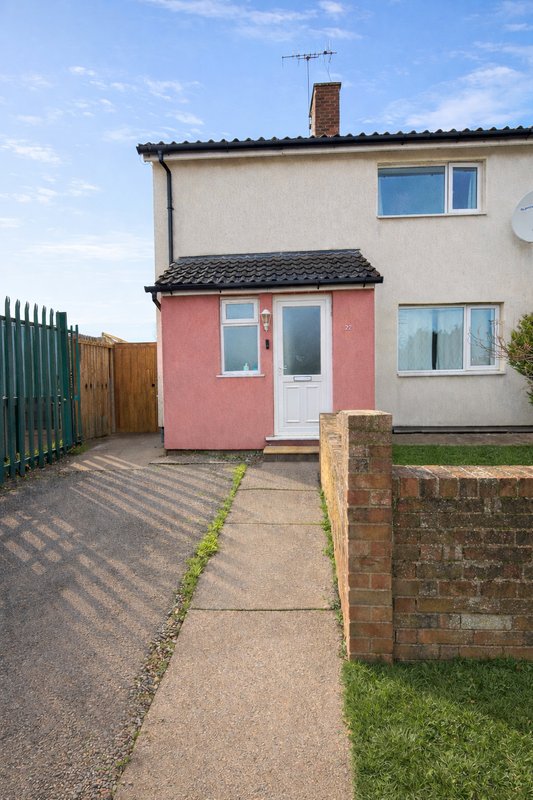 Semi-detached house with pink extension, driveway, and brick boundary wall