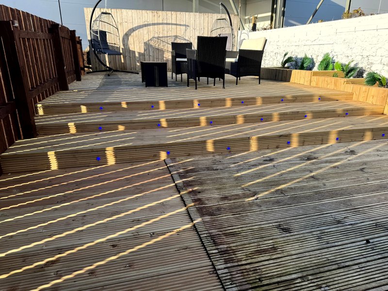 Rooftop terrace with wooden decking, outdoor seating area and potted plants