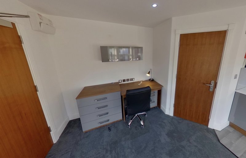 Bedroom workspace with desk, chair, drawers and wooden doors