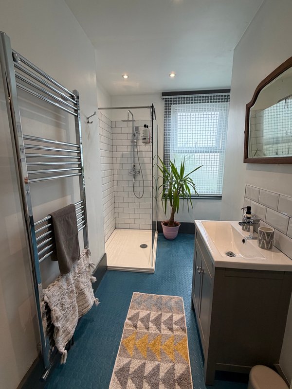 Modern bathroom with walk-in shower, heated towel rail, sink vanity and window