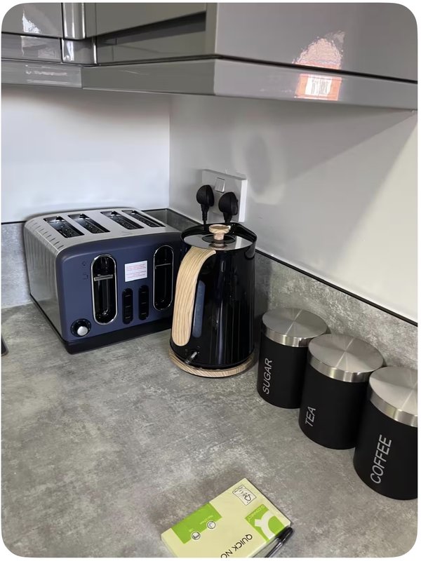 Kitchen counter with toaster, kettle, coffee canisters and utensil holder