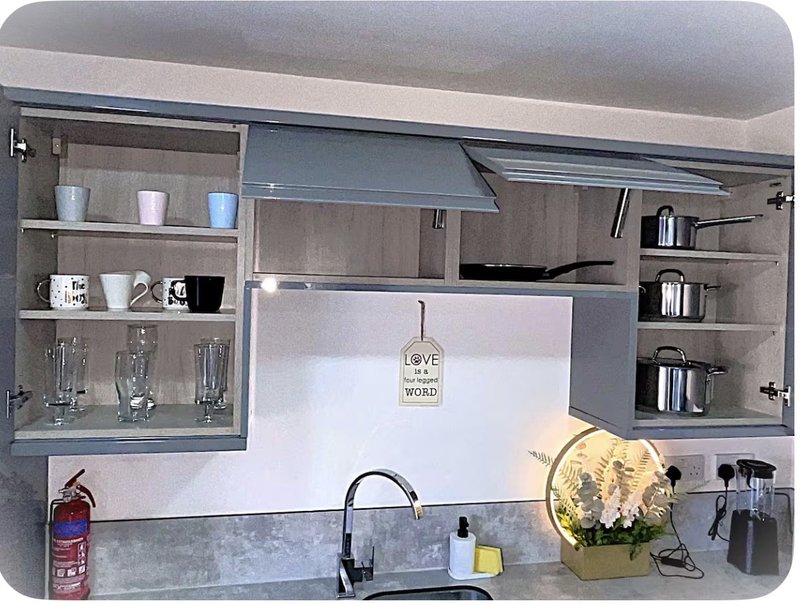 Modern kitchen with open shelving, sink, tap, decorative items and white backsplash