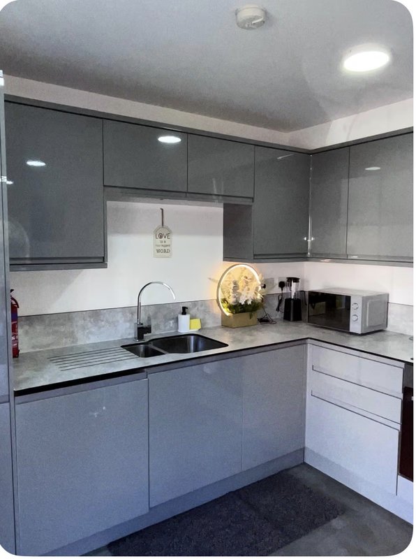 Modern kitchen with dark cabinetry, white countertop, sink, and stainless steel appliances