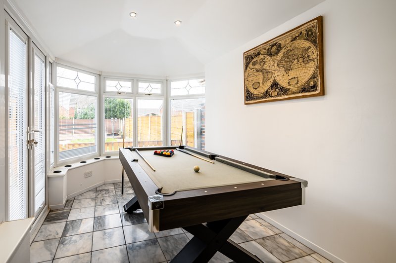 Spacious games room with pool table, bay windows, tiled floor and wall map artwork