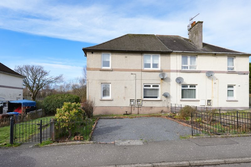 Cream-coloured two-storey residential house with driveway, front garden and black metal fencing