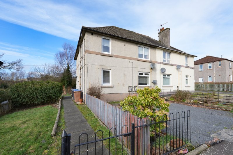 Semi-detached house with cream render, multiple windows, metal fence and front garden
