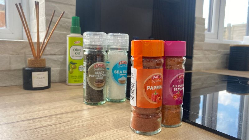 Kitchen counter with spice jars, reed diffuser, candle, and small appliances