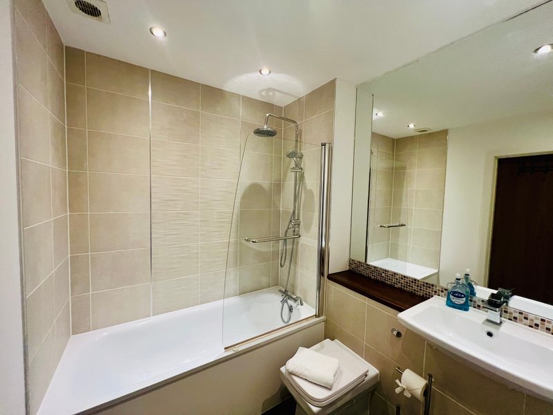 Modern bathroom with walk-in shower, bathtub, double sink vanity and mirror