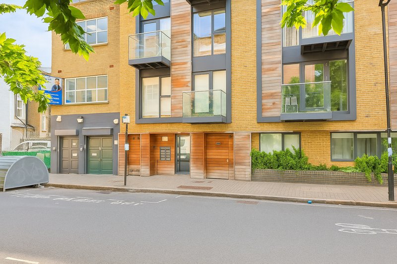 Modern brick apartment building exterior with ground-floor entrance and street frontage