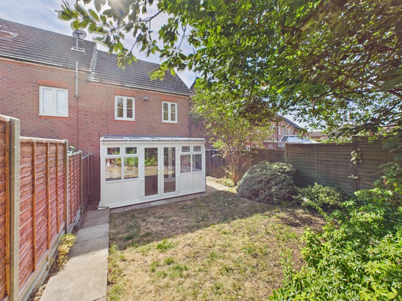 Brick house with garden extension, patio area and mature trees surrounding property