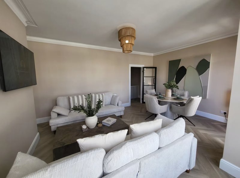 Modern living room with white sofas, wooden coffee table, pendant lamp and contemporary wall art