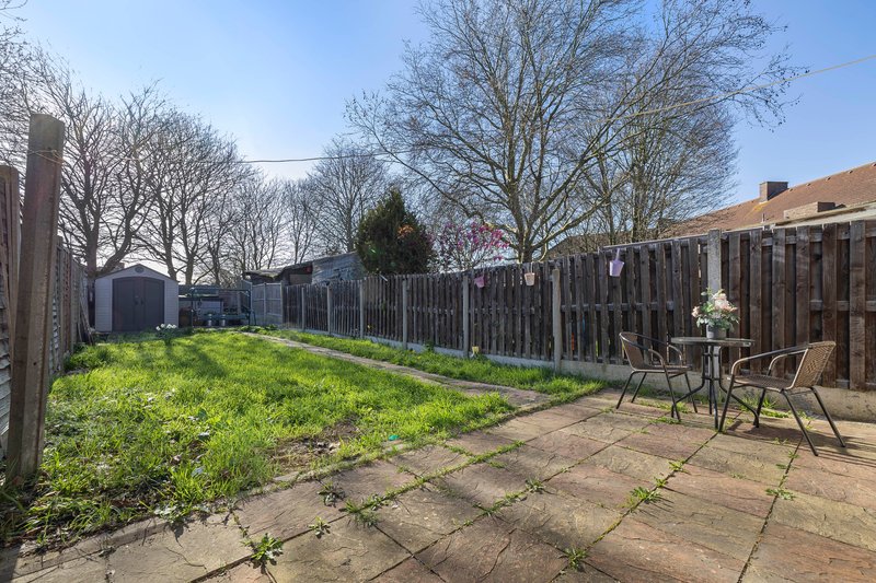 Rear garden with patio, wooden fencing, chairs and bare trees