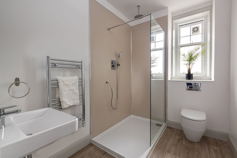 Modern bathroom with walk-in shower, white sink, heated towel rail and toilet