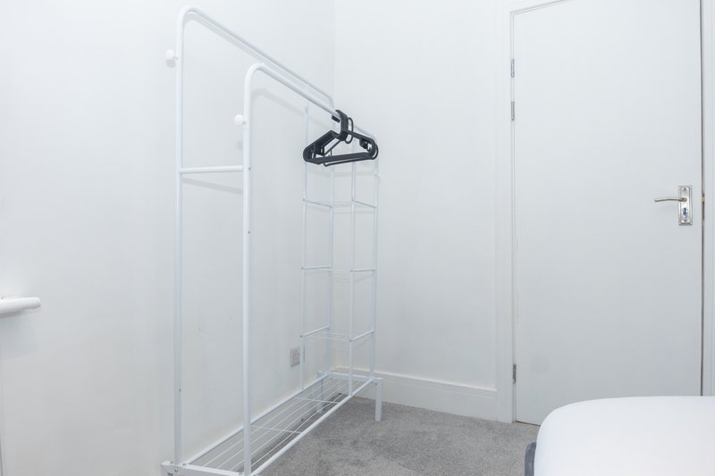 Modern bathroom with walk-in shower, rainfall showerhead, glass enclosure and white walls
