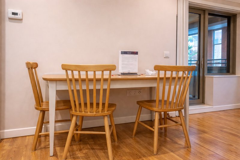 Dining area with wooden table, two chairs, and glass doors to outdoor space
