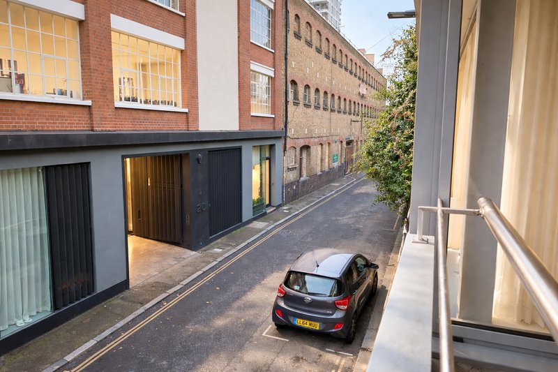 Street view of brick buildings with parked car and modern storefronts below