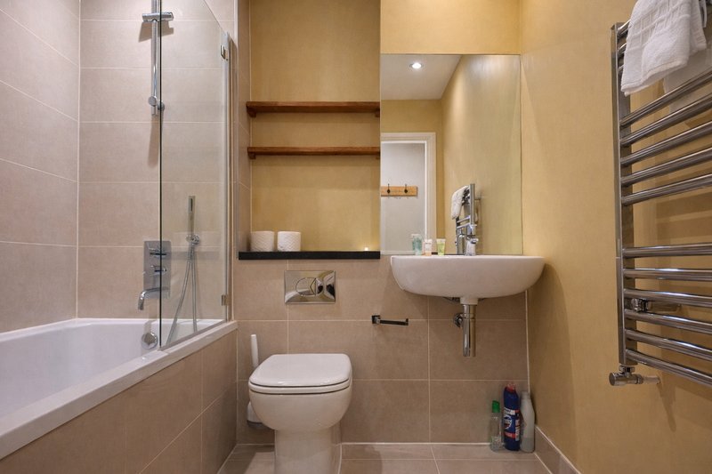 Modern bathroom with bathtub, shower enclosure, toilet, sink and heated towel rail