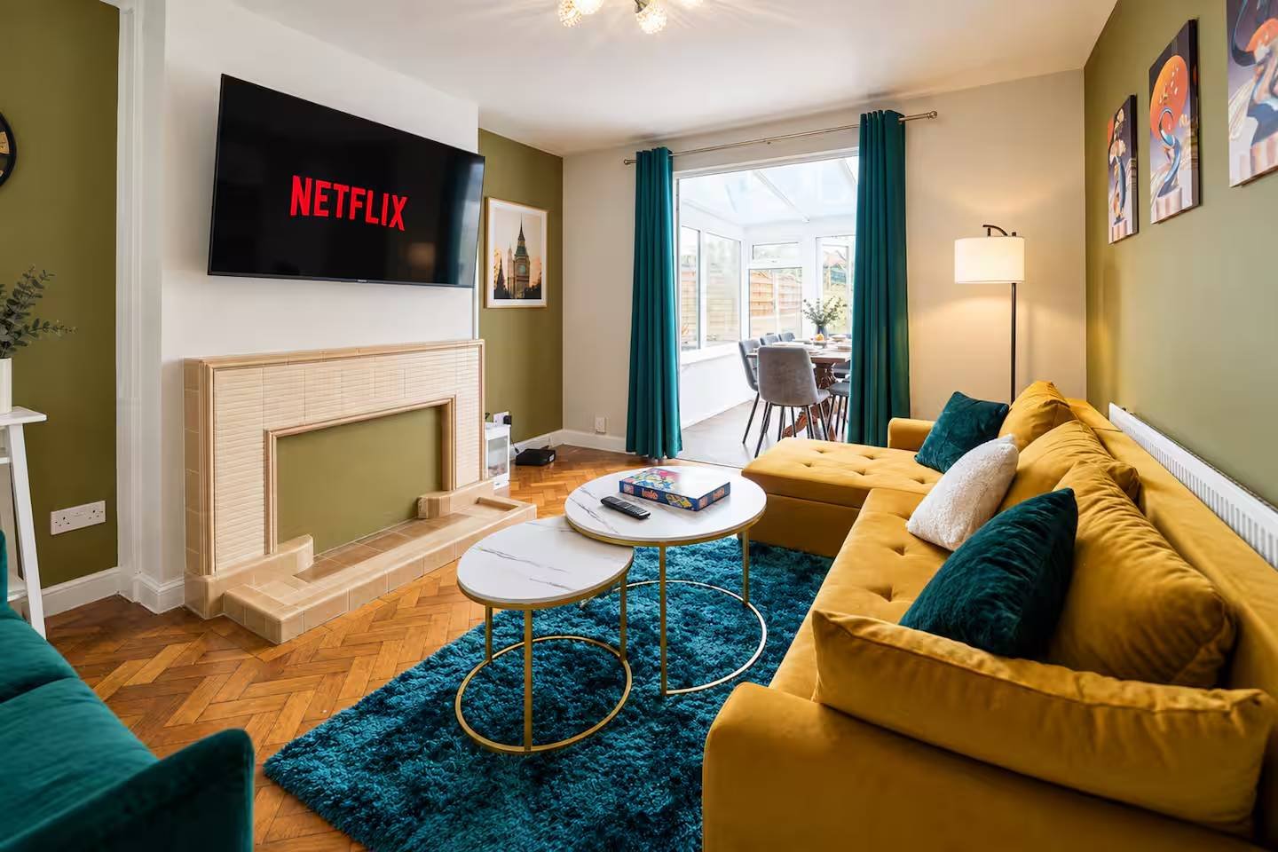 Modern living room with yellow sofa, fireplace, TV, and teal accents